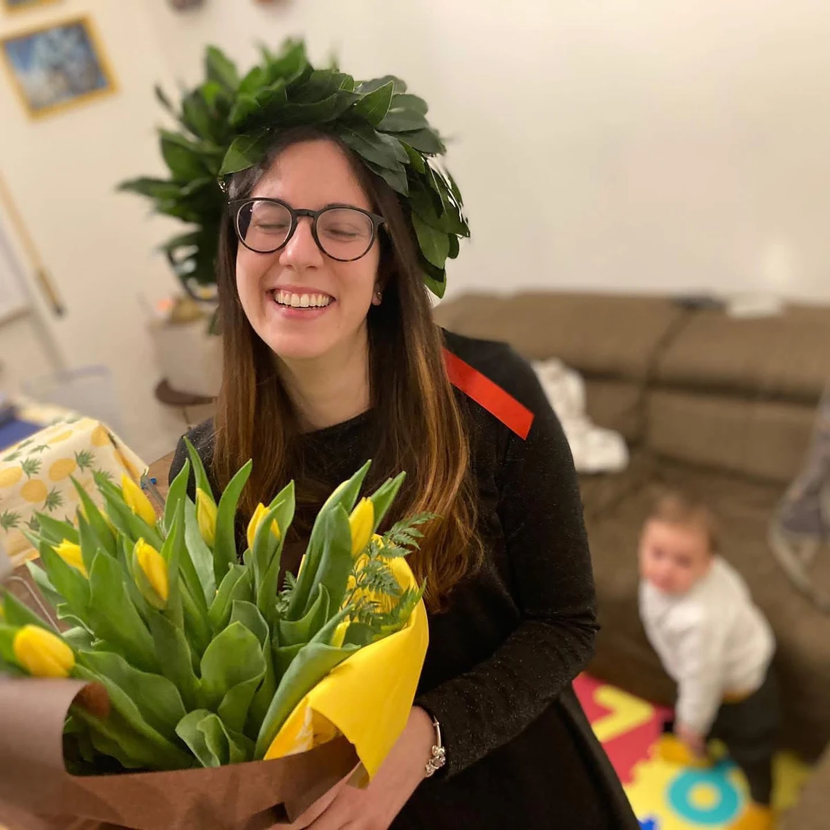 Marinella Vicini con la corona di alloro e un mazzo di tulipani gialli il giorno della laurea