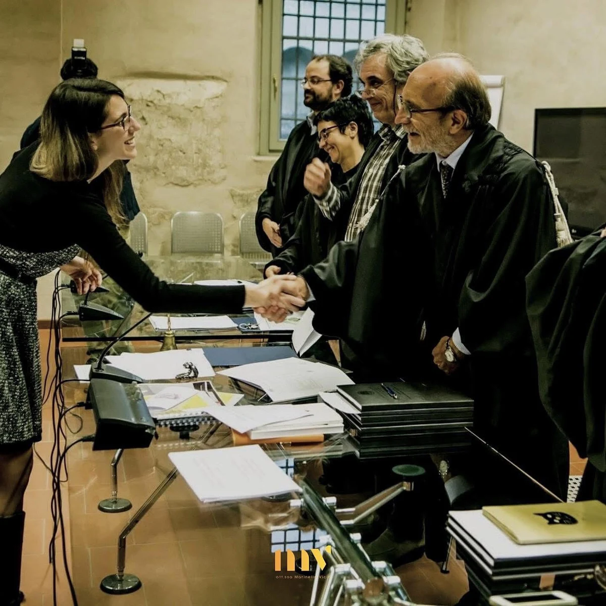Marinella Vicini stringe la mano alla commissione al termine della discussione della tesi di laurea