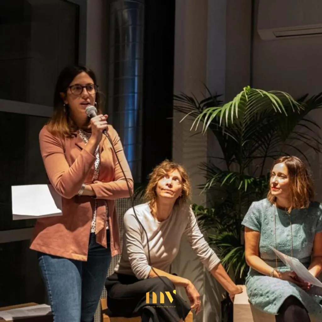 Le professioniste dell'associazione Empatia sedute durante la serata di presentazione, una di loro parla al microfono
